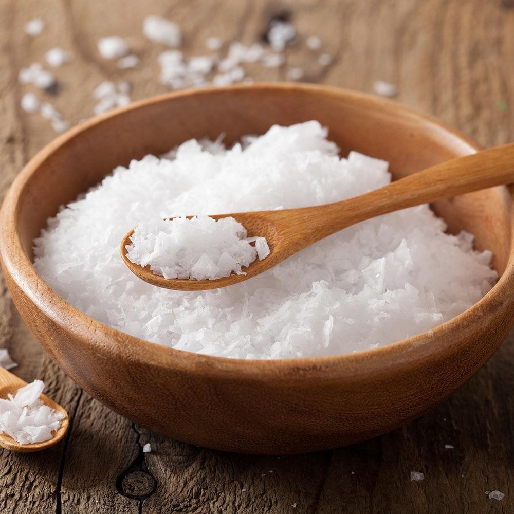 White magnesium chloride flakes in a wooden bowl
